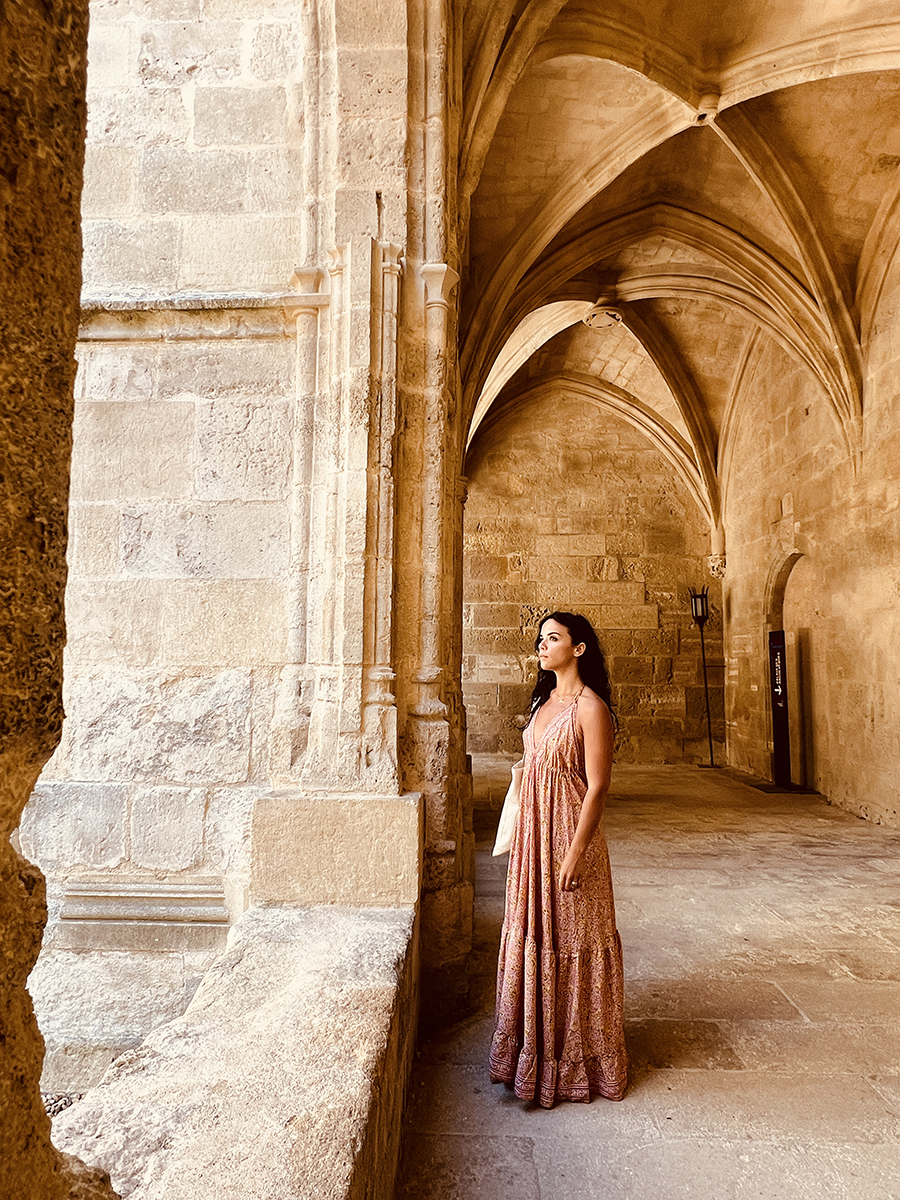 Woman standing beneath the grand arch of a massive cathedral in the South of France — blending human presence with stunning historic architecture and French heritage
