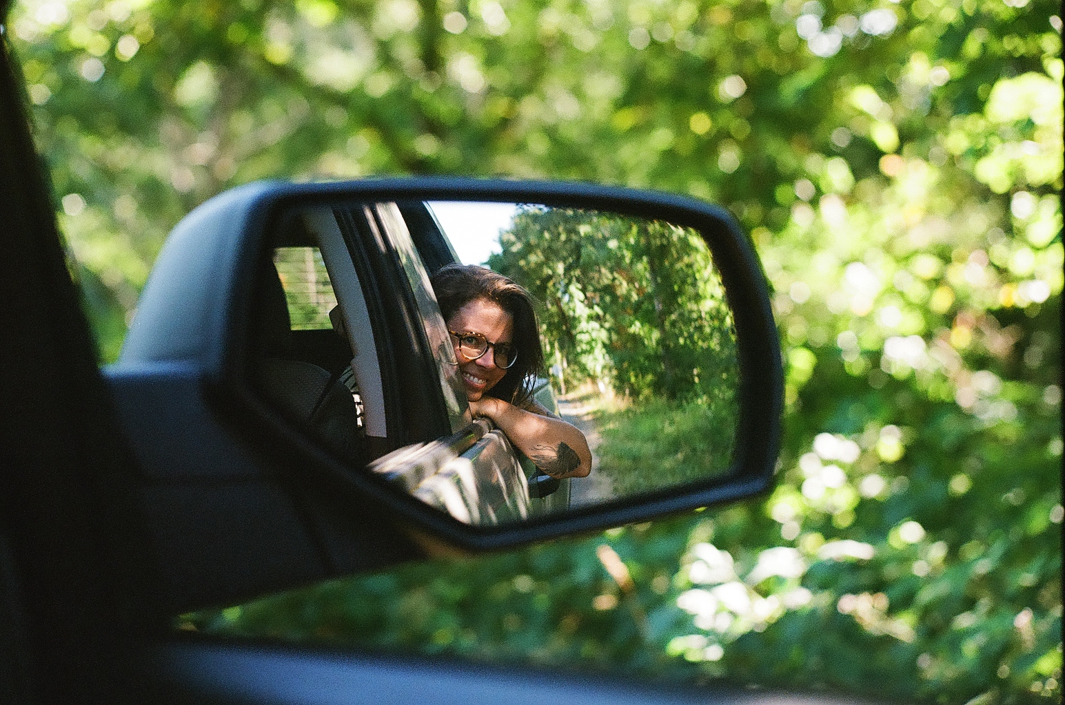 a woman through the rear mirror of a car